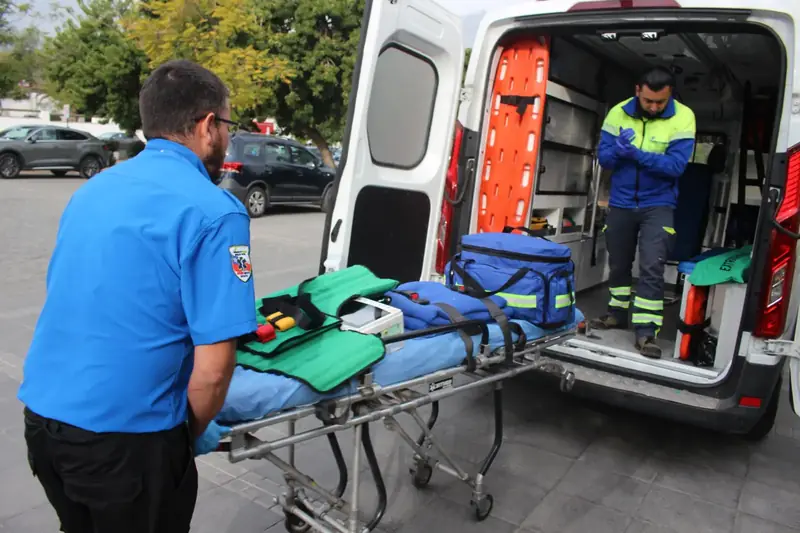 Equipo REST911 preparando la camilla junto a la ambulancia